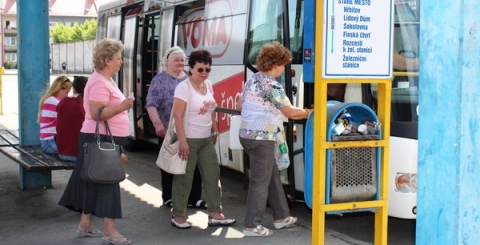 Lidé nastupující do autobusu na autobusovém nádraží UH